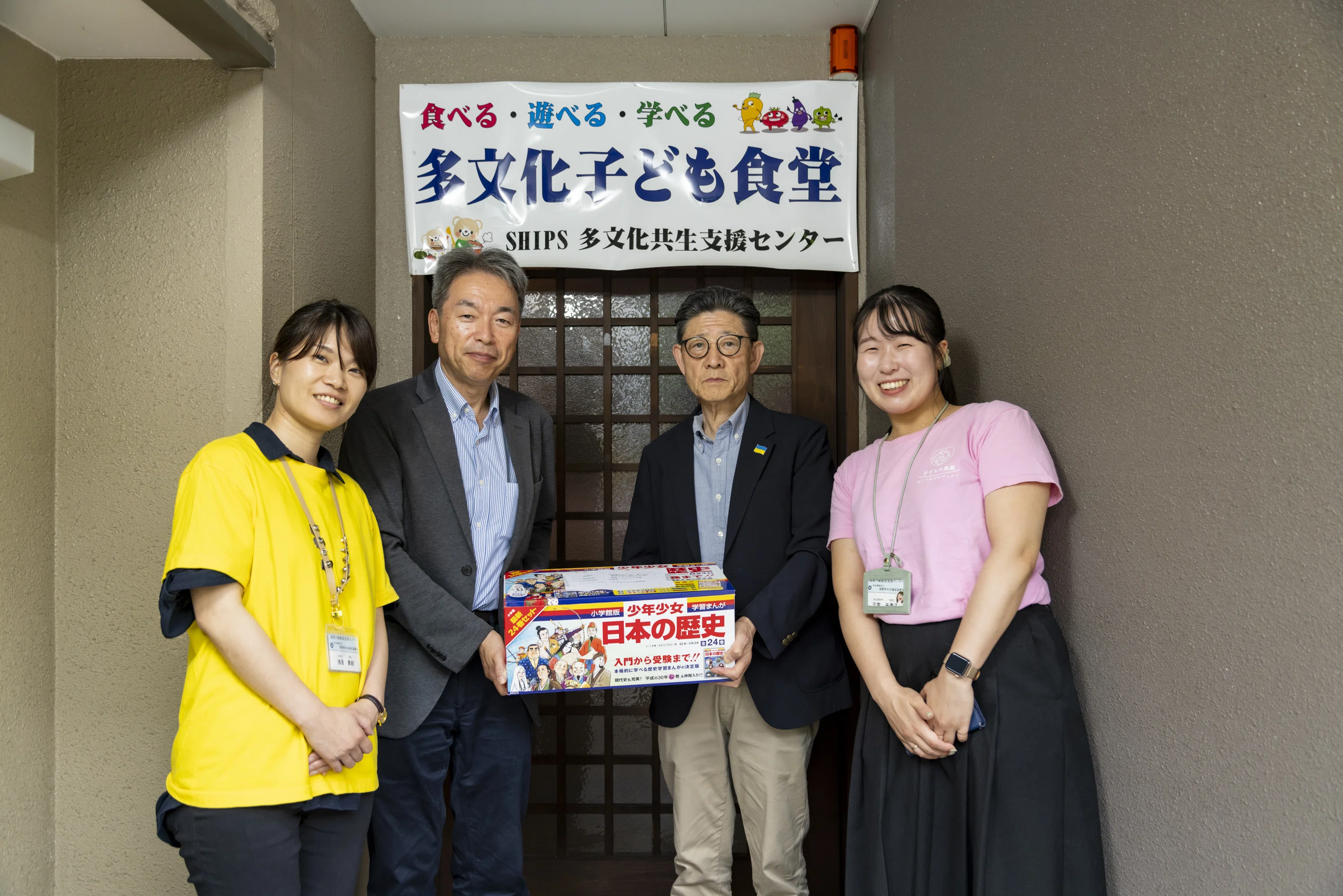 県社協のおふたりと、書籍の寄贈先のひとつである「多文化子ども食堂」（草津市）の代表の喜久川さん