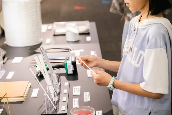 ガラスファイバを使って複合強化された試験片を手に取る学生